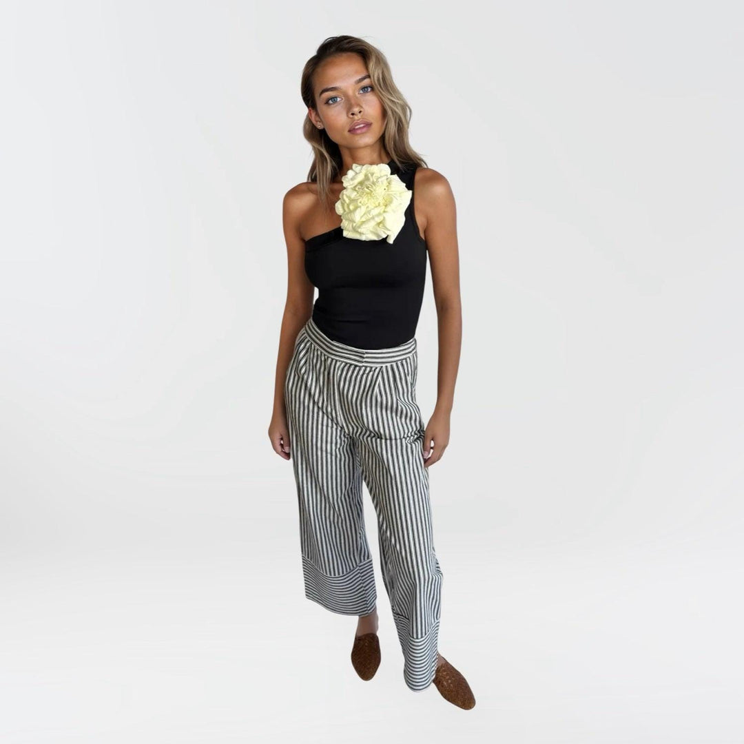 Black one shoulder top with white flower pin
