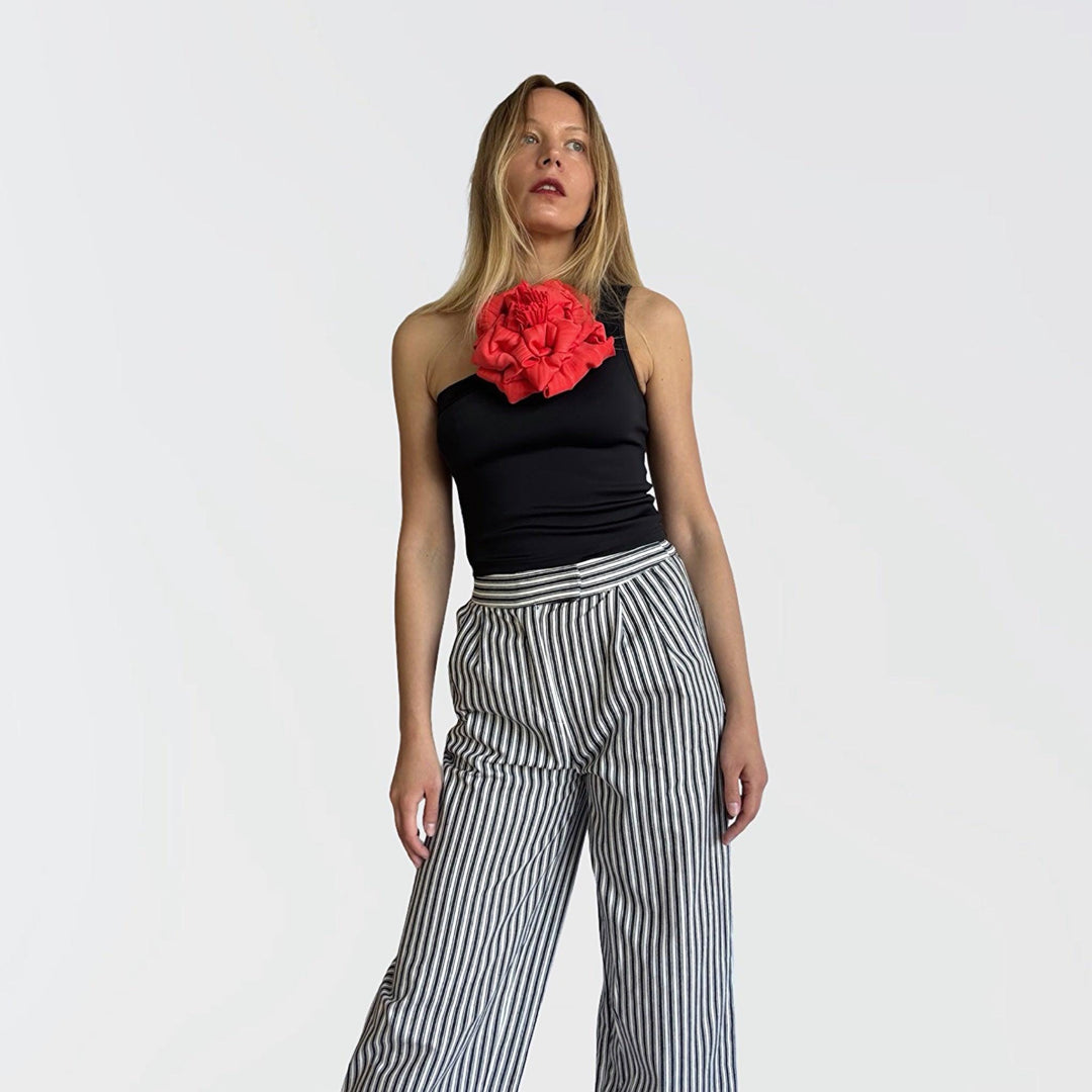 Black one shoulder top with red flower pin