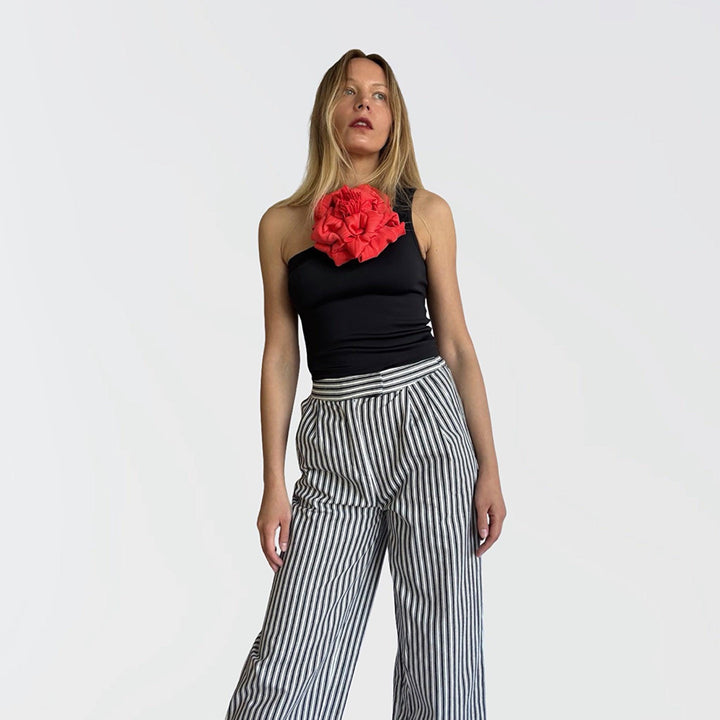 Black one shoulder top with red flower pin