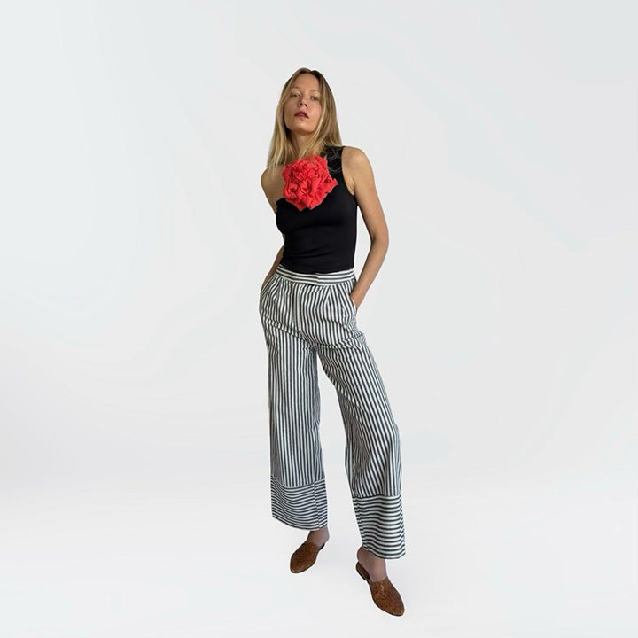Black one shoulder top with red flower pin