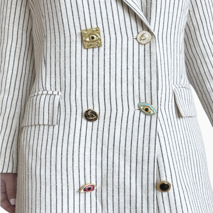 Ivory pin stripe linen double breasted suit with surrealist eye buttons