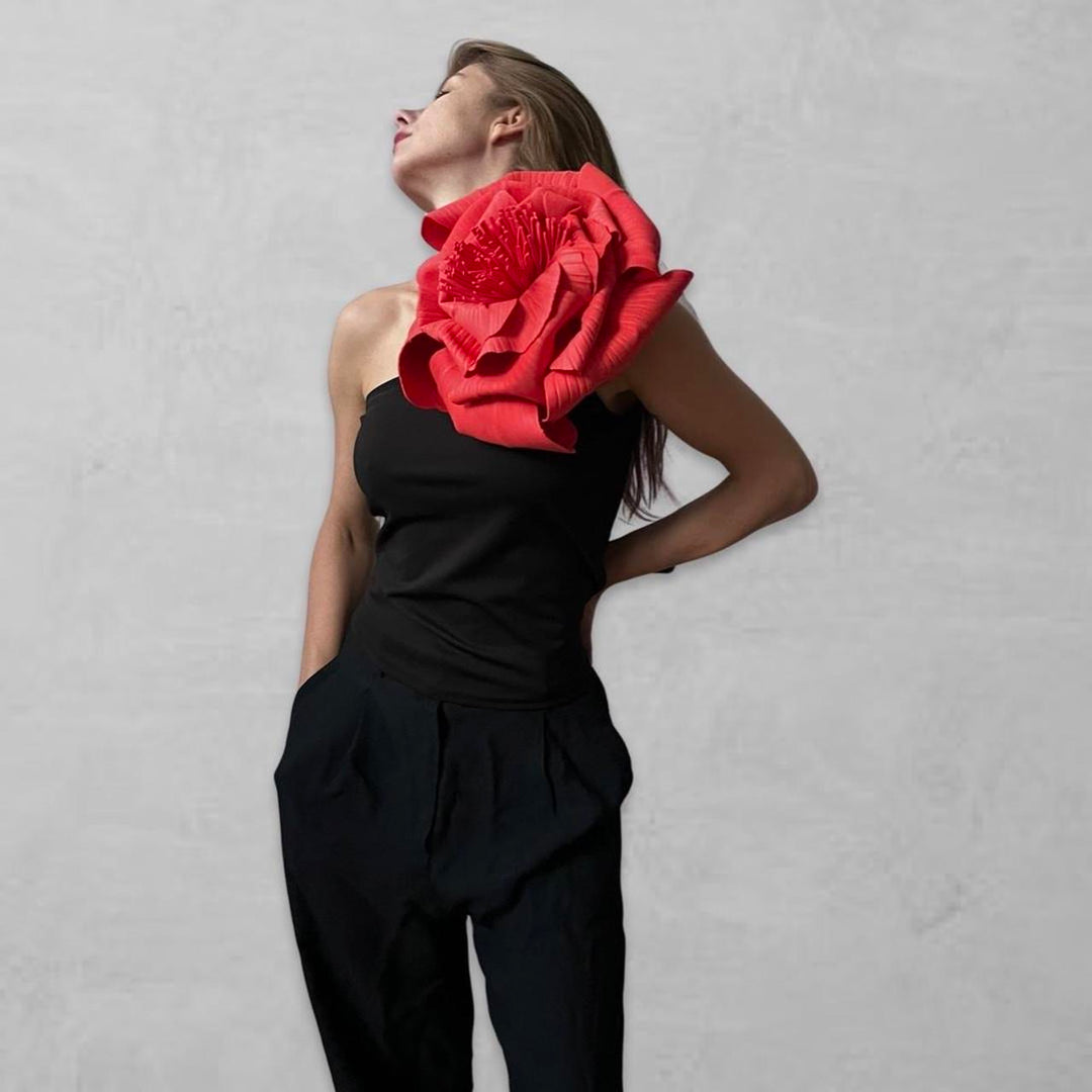 Black one shoulder top with red flower pin