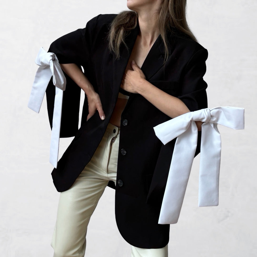 Reworked black blazer with cut out sleeves and white bows