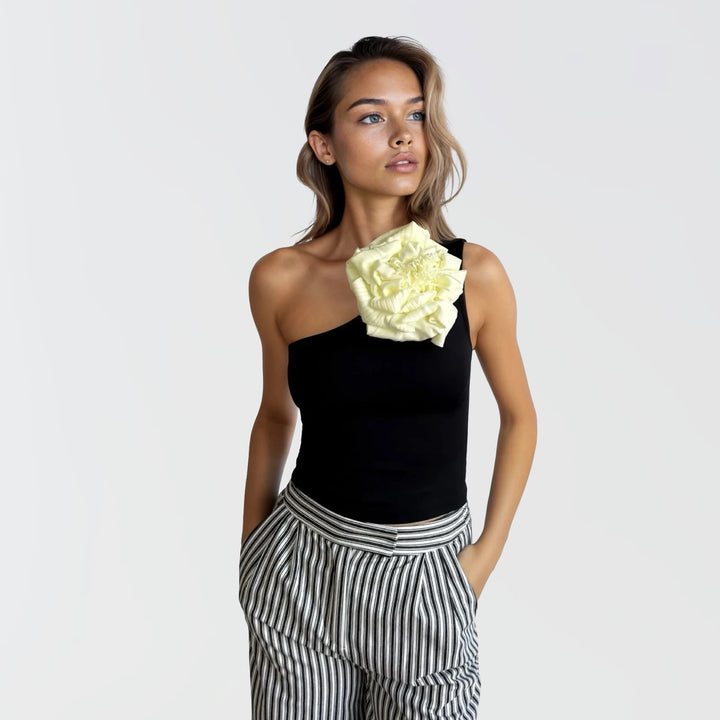 Black one shoulder top with white flower pin