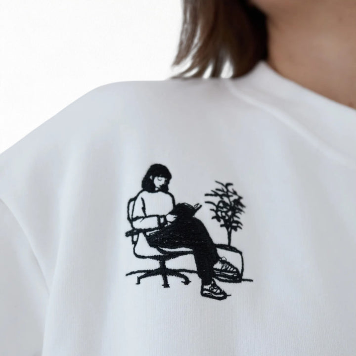 White heavyweight jumper with people embroidery