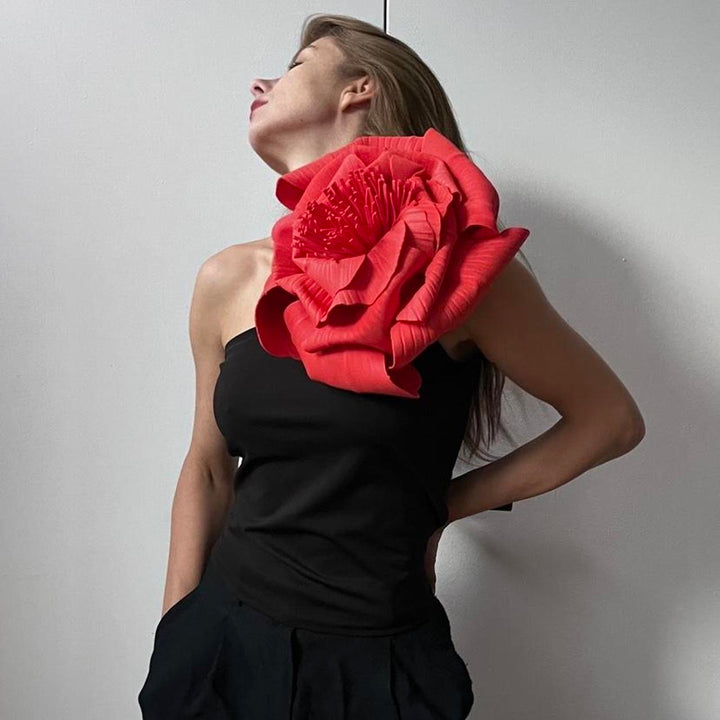 Black one shoulder top with red flower pin