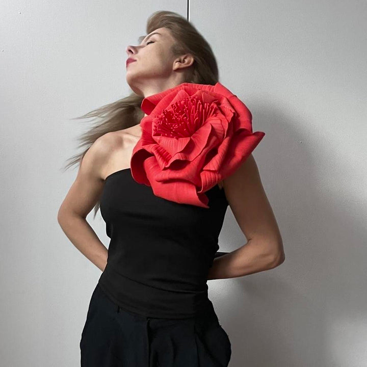 Black one shoulder top with red flower pin