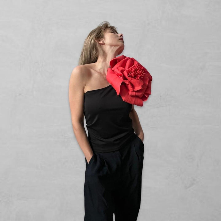 Black one shoulder top with red flower pin