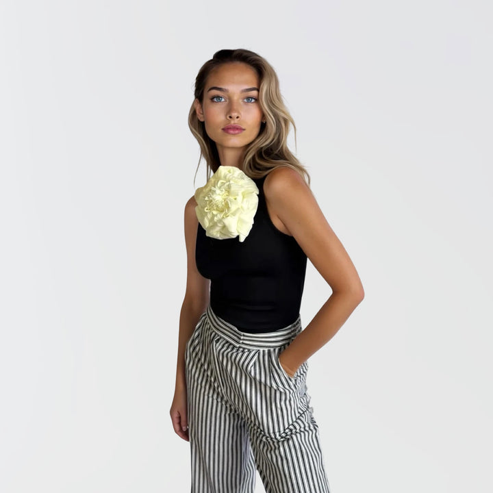 Black one shoulder top with white flower pin
