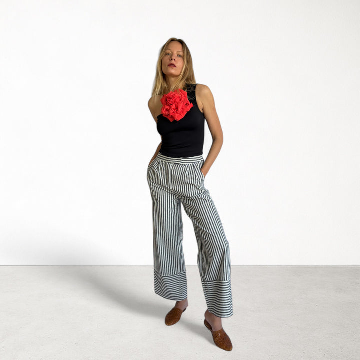 Black one shoulder top with red flower pin
