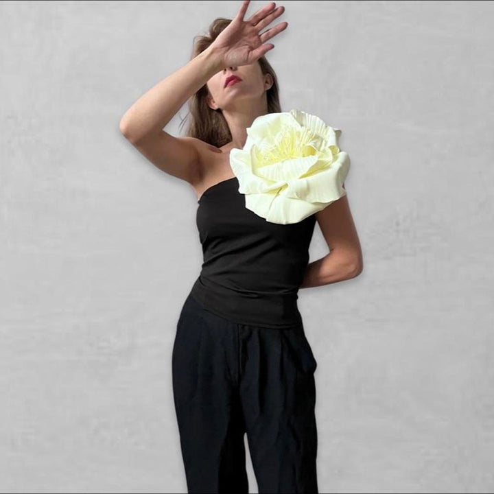 Black one shoulder top with white flower pin