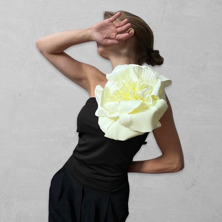 Black one shoulder top with white flower pin