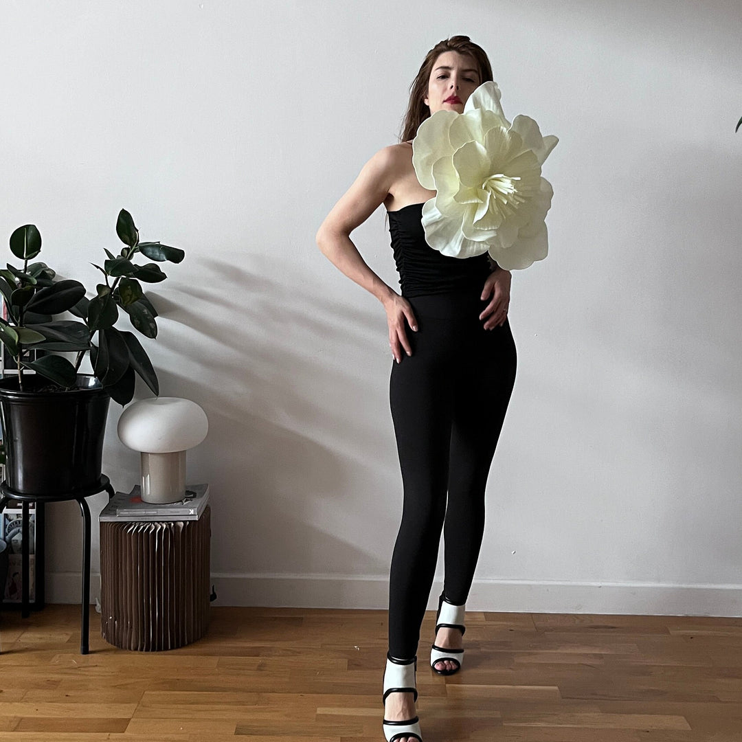 Black one shoulder top with white flower pin