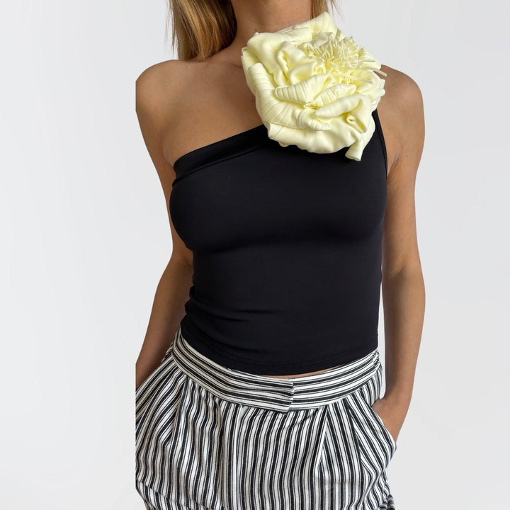 Black one shoulder top with white flower pin