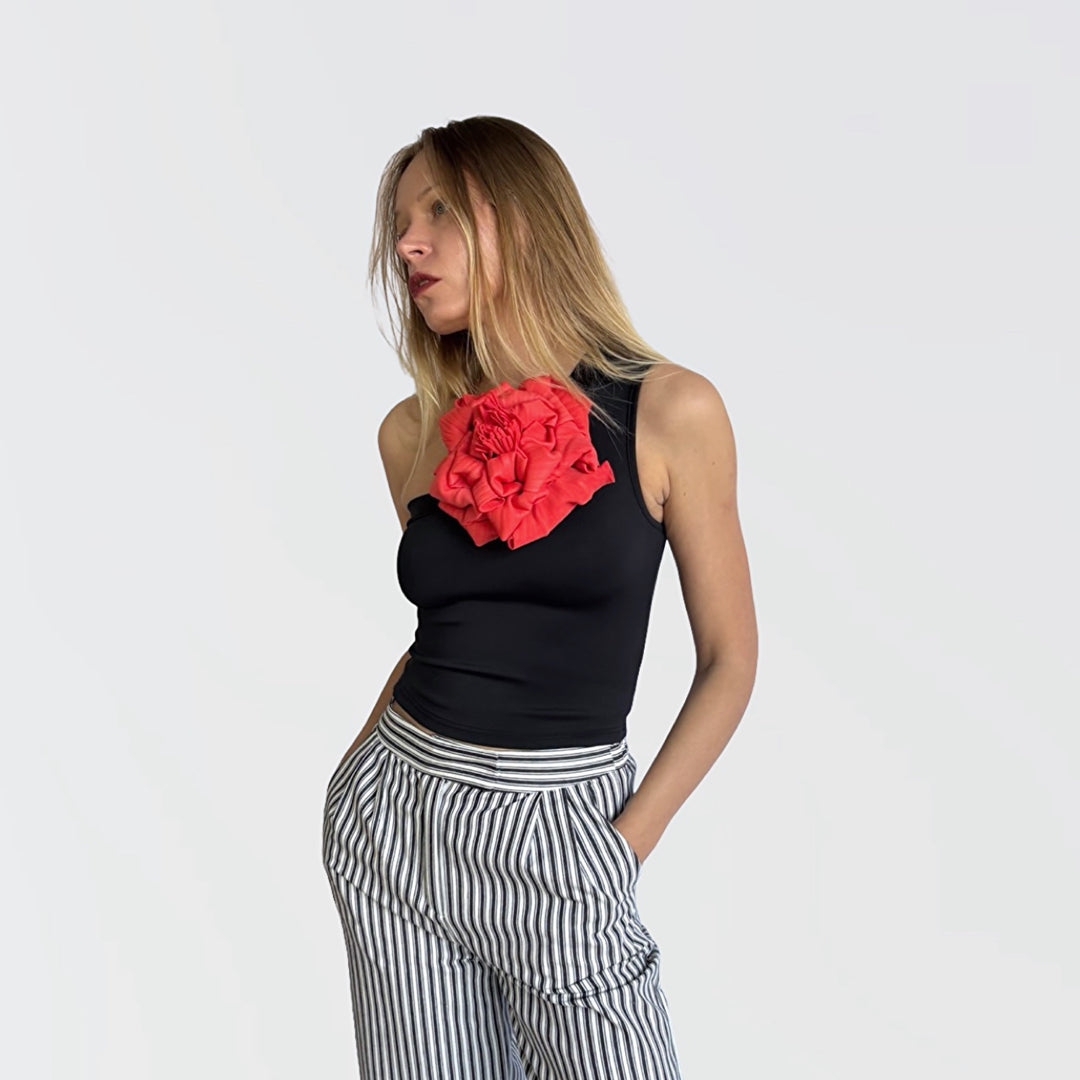 Black one shoulder top with red flower pin