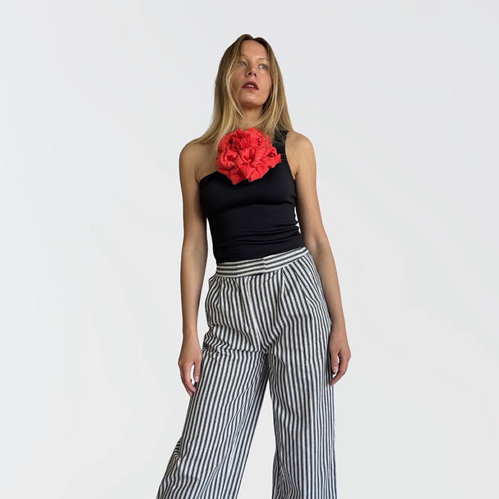 Black one shoulder top with red flower pin