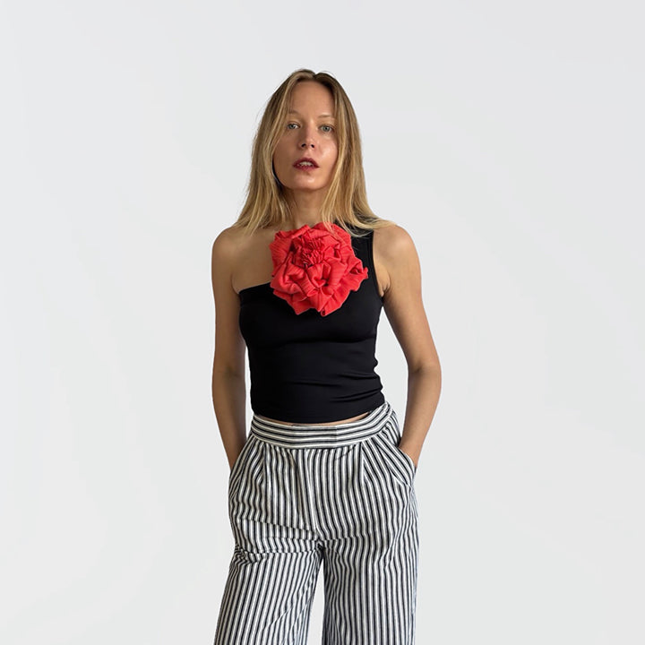 Black one shoulder top with red flower pin