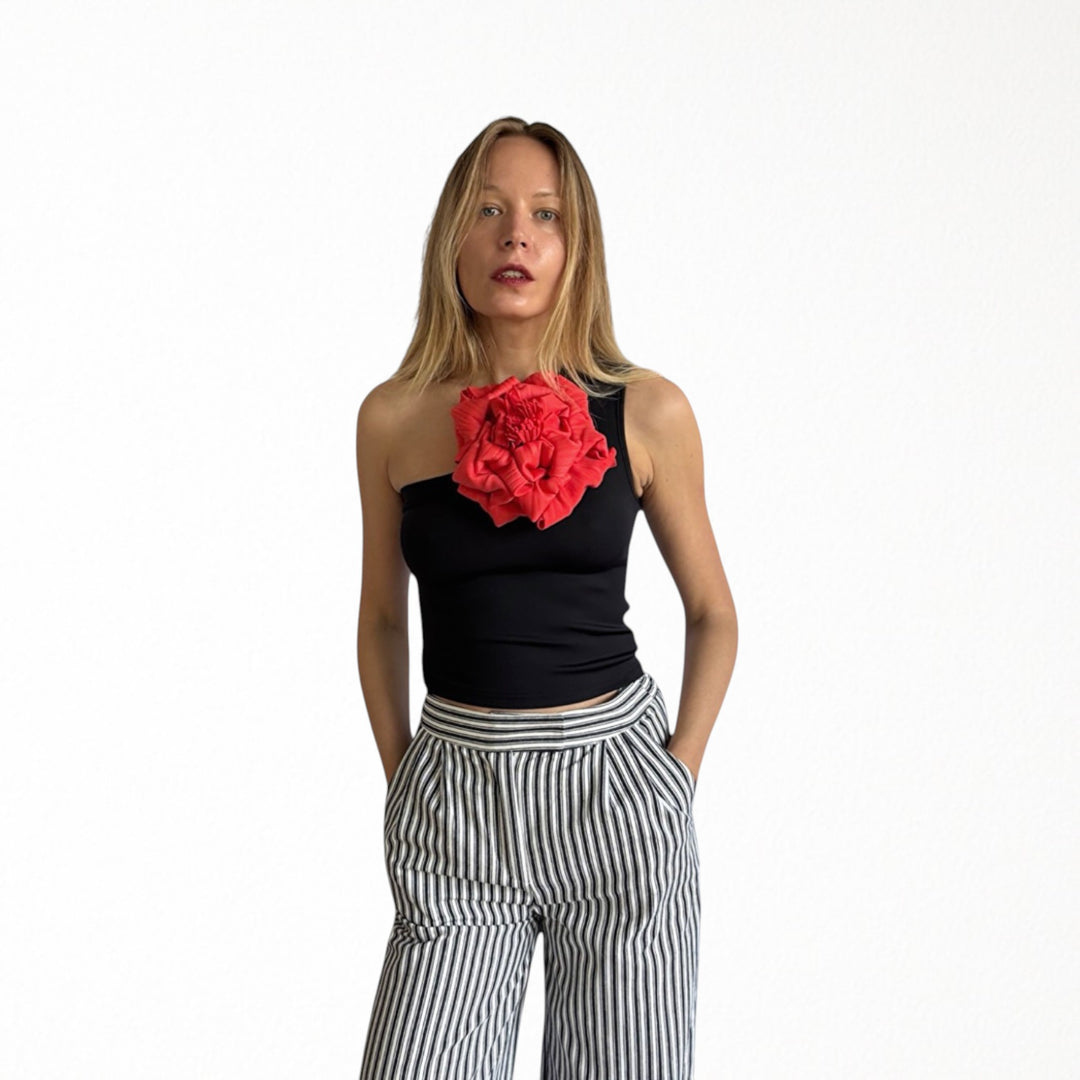 Black one shoulder top with red flower pin