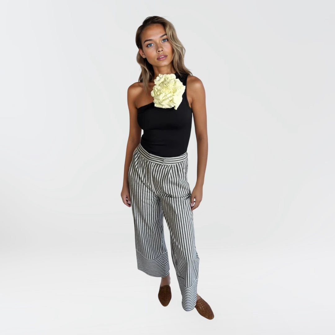 Black one shoulder top with white flower pin