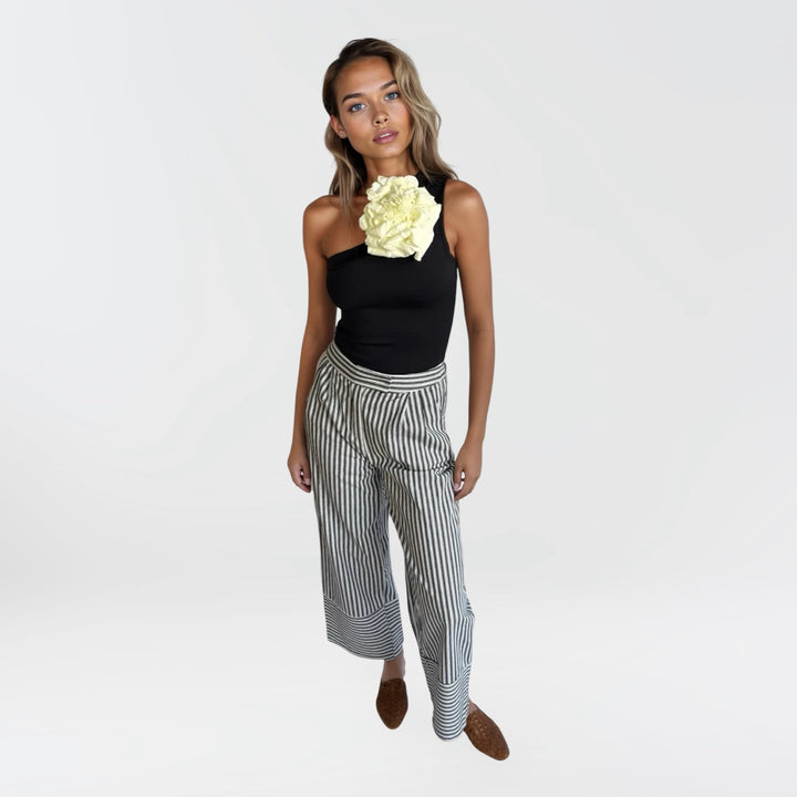 Black one shoulder top with white flower pin