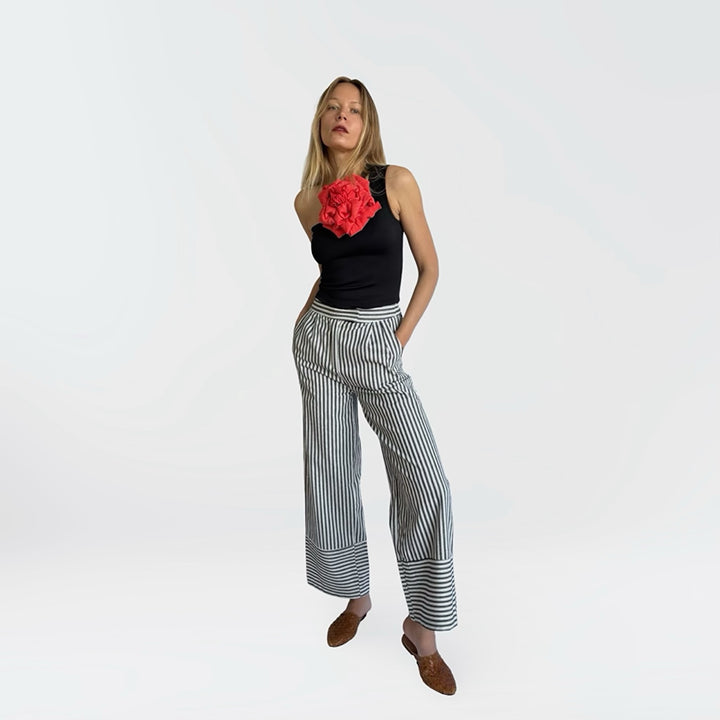 Black one shoulder top with red flower pin