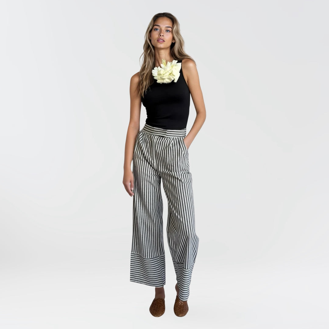 Black one shoulder top with white flower pin