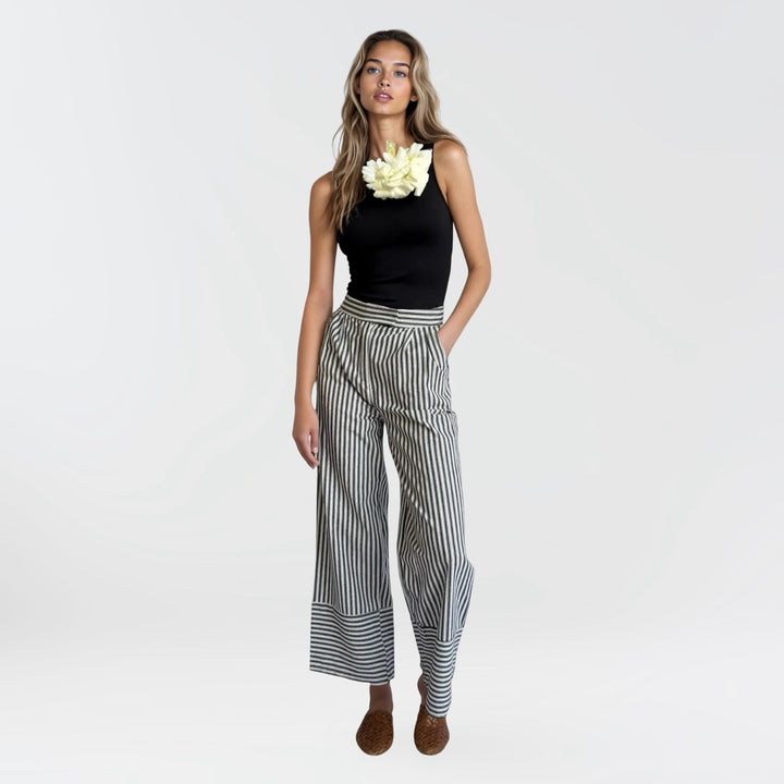 Black one shoulder top with white flower pin