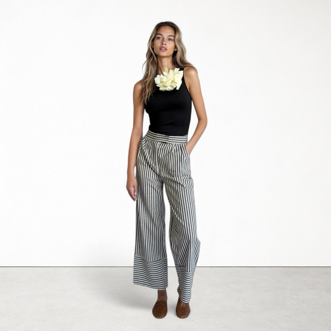 Black one shoulder top with white flower pin