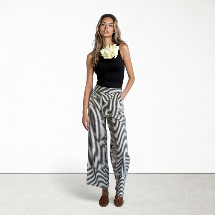 Black one shoulder top with white flower pin