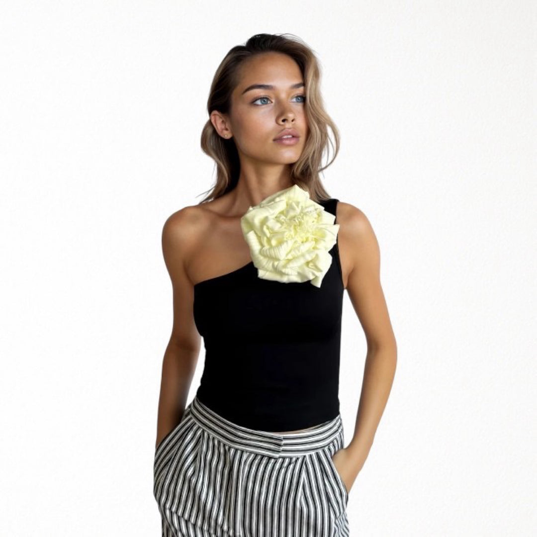 Black one shoulder top with white flower pin