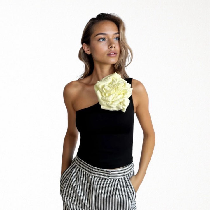 Black one shoulder top with white flower pin
